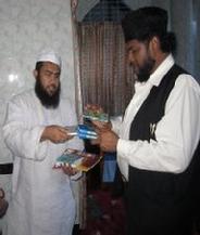 Shaikh Shafayat receiving some books from the Director of Madrasah Bait-ul-Uloom, Gendaria Dhaka